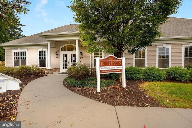 exterior space featuring french doors and a shingled roof