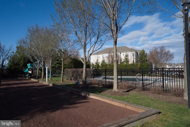 view of yard featuring playground community and fence