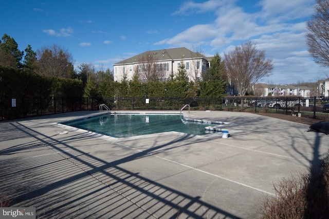 community pool featuring fence and a patio area