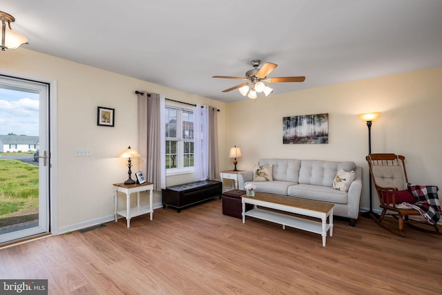 living area with ceiling fan, baseboards, light wood-style flooring, and visible vents