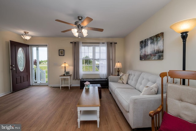 living room featuring baseboards, wood finished floors, and a ceiling fan