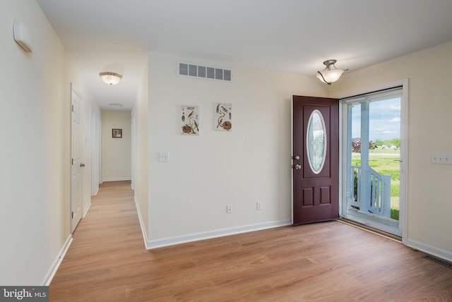 foyer entrance featuring visible vents, baseboards, and light wood-type flooring