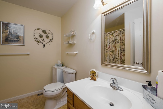 bathroom featuring toilet, vanity, tile patterned flooring, and baseboards