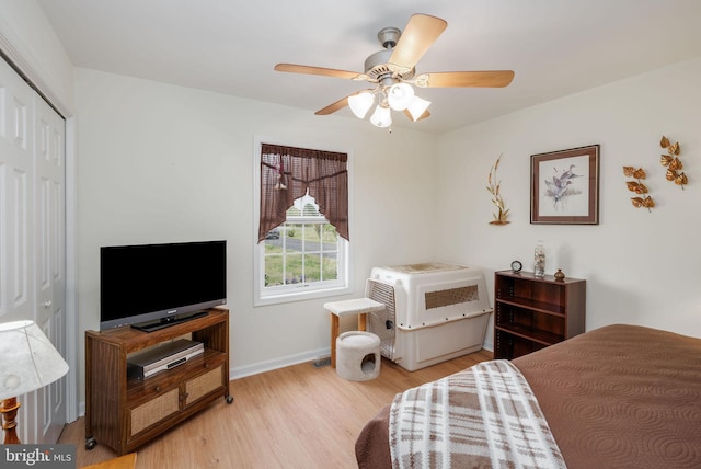 bedroom with a closet, ceiling fan, wood finished floors, and baseboards