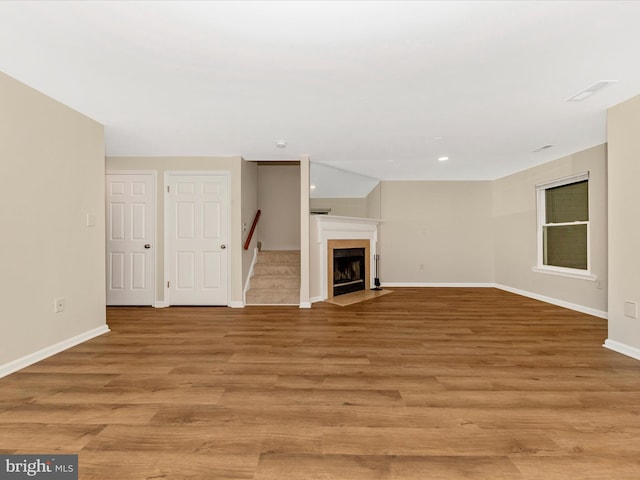 20216 Tidewinds Way, Germantown, MD 20874 - unfurnished living room featuring baseboards, light wood-type flooring, a fireplace with flush hearth, and recessed lighting