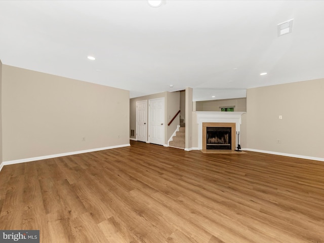 20216 Tidewinds Way, Germantown, MD 20874 - unfurnished living room with baseboards, light wood finished floors, recessed lighting, a fireplace with flush hearth, and stairway
