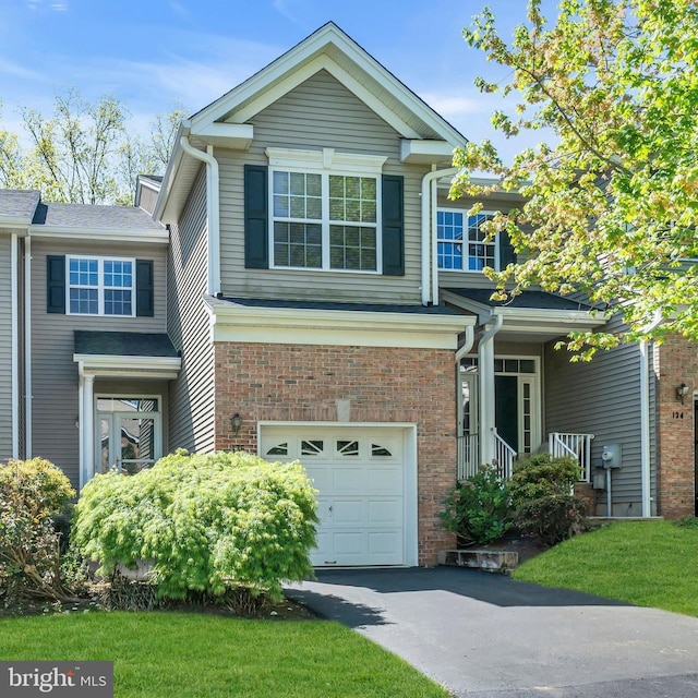 view of front of home featuring brick siding, a garage, and aphalt driveway