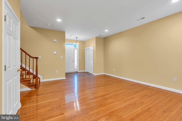 entryway with baseboards, light wood-style flooring, and stairs