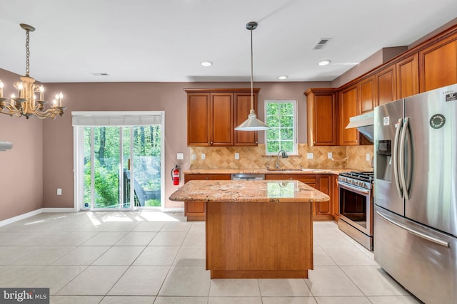 kitchen with visible vents, brown cabinetry, appliances with stainless steel finishes, and light stone counters