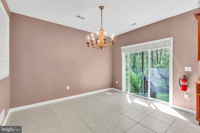 spare room with baseboards, a notable chandelier, light tile patterned floors, and visible vents