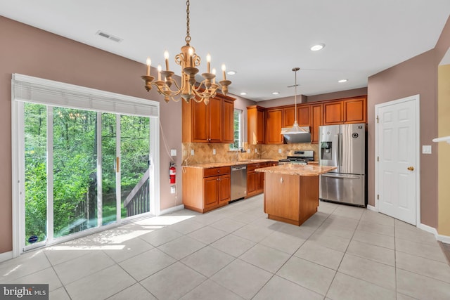 kitchen with light stone counters, a sink, stainless steel appliances, backsplash, and visible vents