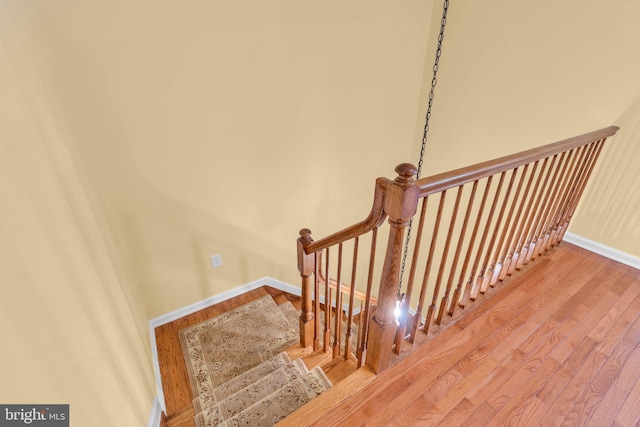 stairway with baseboards and wood finished floors