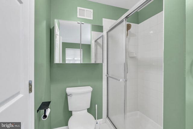 full bathroom featuring visible vents, baseboards, a stall shower, and toilet