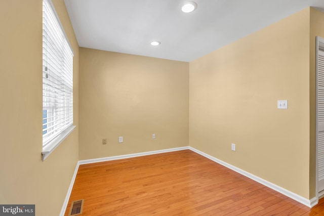 empty room featuring light wood-type flooring, recessed lighting, baseboards, and visible vents