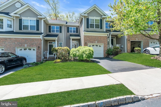 townhome / multi-family property featuring an attached garage, a front lawn, driveway, and brick siding