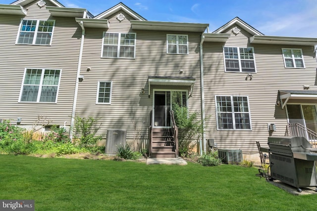 rear view of house with a yard, entry steps, and central air condition unit