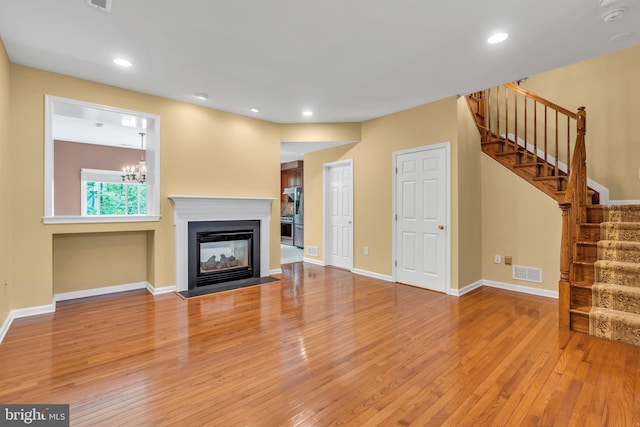 unfurnished living room with visible vents, stairs, baseboards, recessed lighting, and hardwood / wood-style floors
