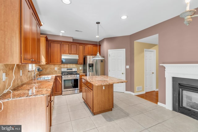 kitchen with visible vents, decorative backsplash, a center island, a sink, and appliances with stainless steel finishes