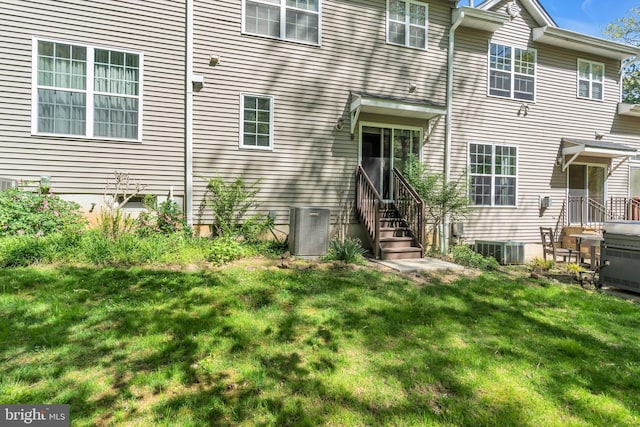 back of property with a lawn and central AC unit
