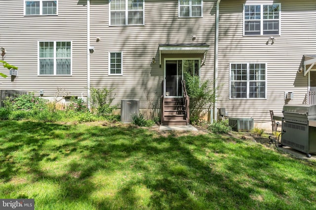 doorway to property with a yard and cooling unit