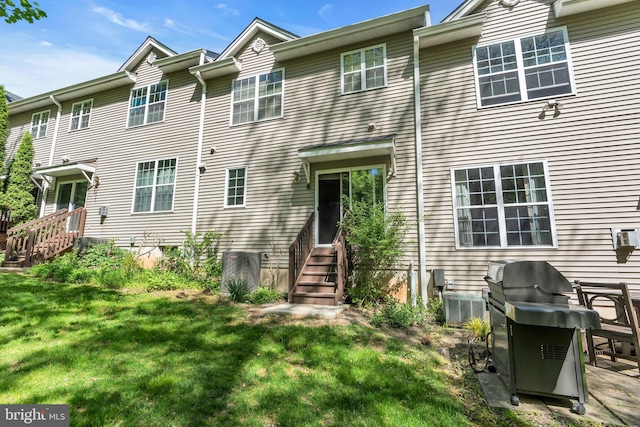 rear view of house with a lawn and entry steps