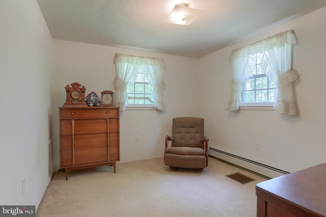 living area with a healthy amount of sunlight, a baseboard radiator, and light colored carpet