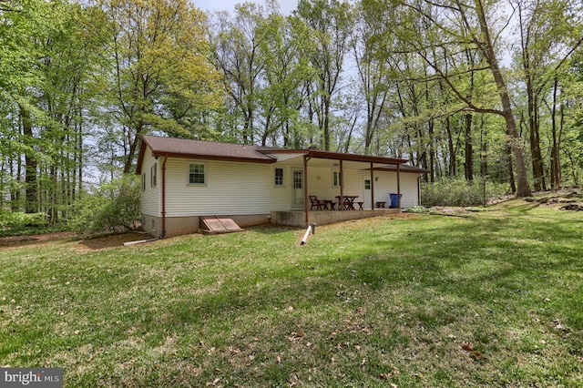 rear view of house featuring a lawn and a patio area