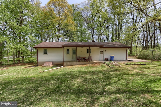 back of property with a lawn and a patio area