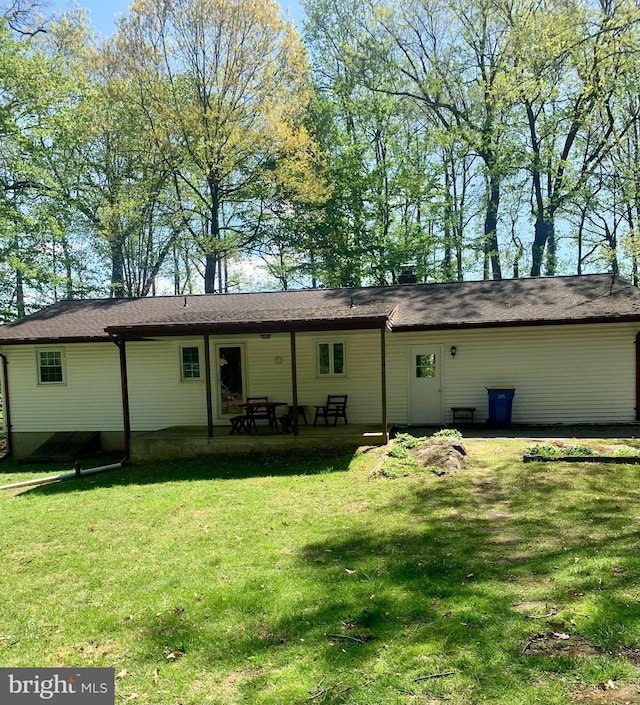 back of house with a lawn and a patio area