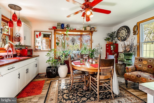 dining area with wood finished floors and a ceiling fan