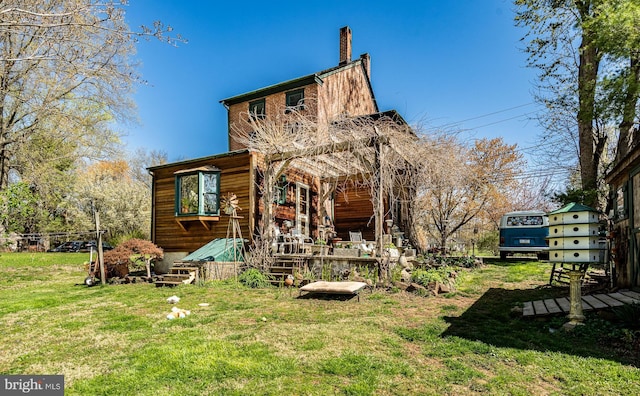 back of property with a lawn and a chimney