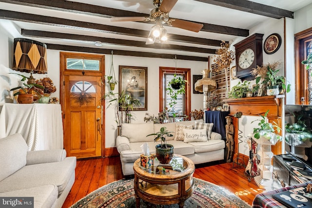 living area featuring beamed ceiling, a ceiling fan, and hardwood / wood-style flooring