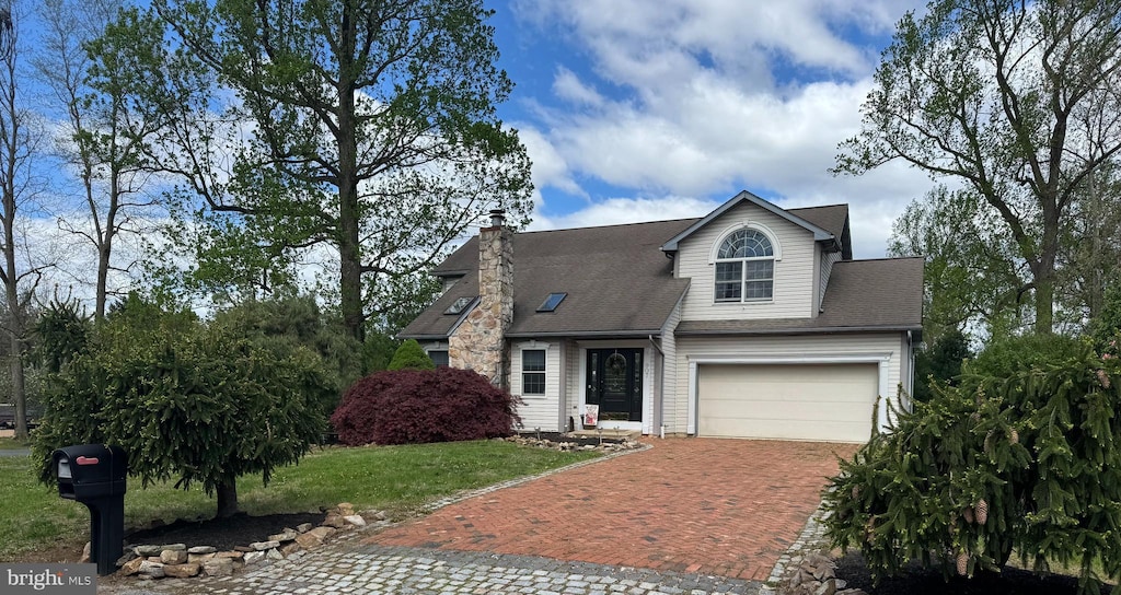 view of front facade featuring a chimney, a shingled roof, decorative driveway, a garage, and a front lawn