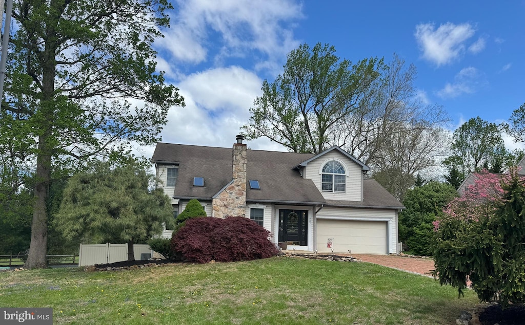 cape cod house with fence, a chimney, driveway, and a front yard