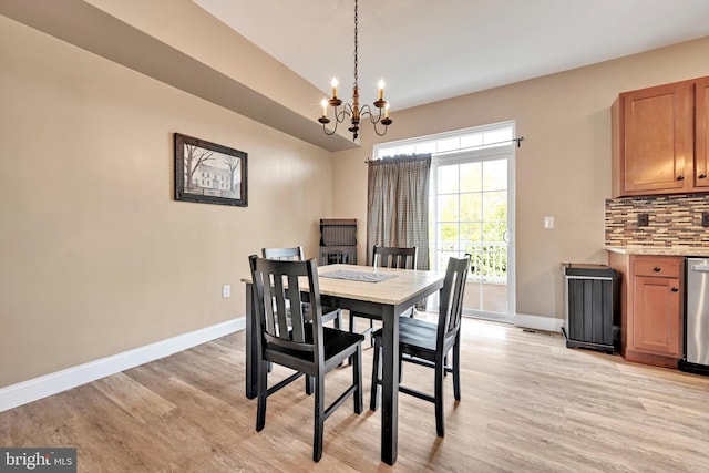 dining room featuring an inviting chandelier, light wood-style flooring, and baseboards