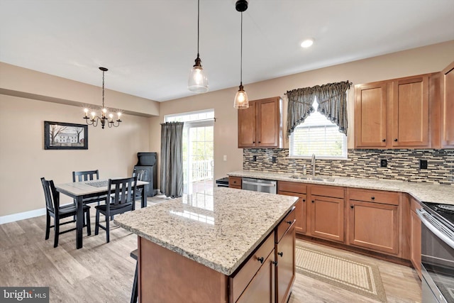 kitchen with light wood-style floors, stainless steel appliances, backsplash, and a sink