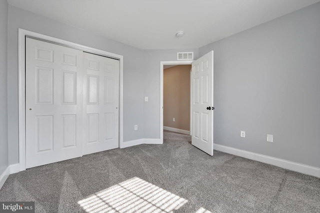 unfurnished bedroom with a closet, visible vents, carpet, and baseboards