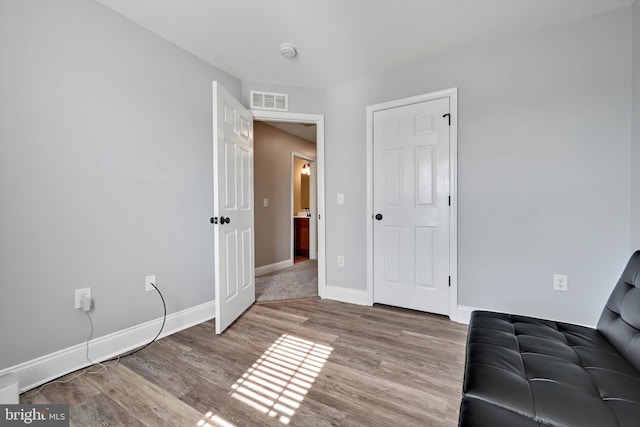 interior space featuring wood finished floors, visible vents, and baseboards