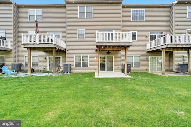 rear view of property featuring cooling unit, a yard, and a patio area