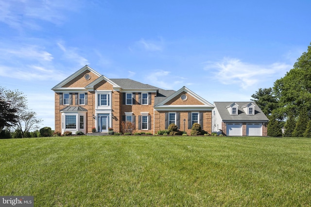 view of front of house with brick siding, a front yard, and a garage