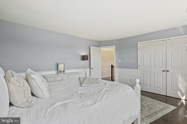 bedroom featuring a closet, a wainscoted wall, and wood finished floors