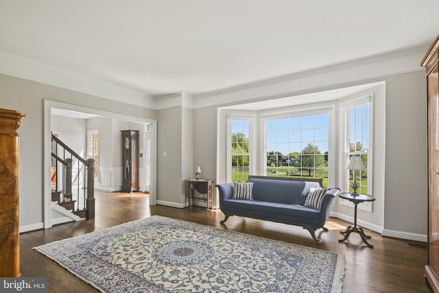 sitting room featuring ornamental molding, stairs, wood finished floors, and a wealth of natural light