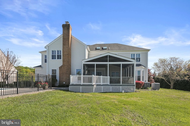 rear view of property with a sunroom, a lawn, a chimney, and cooling unit