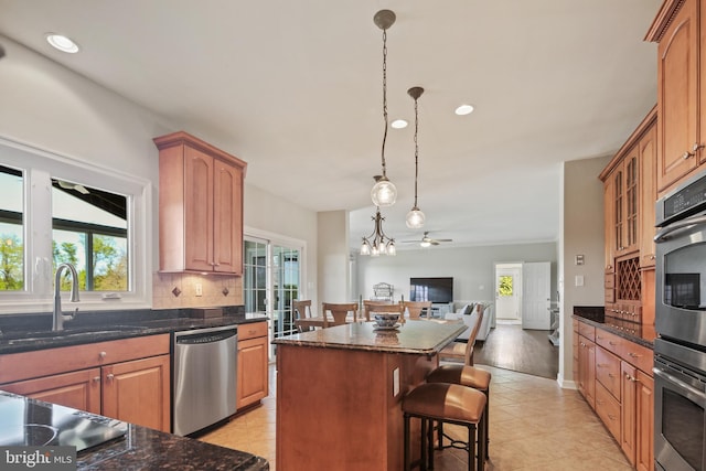 kitchen featuring a center island, a sink, a wealth of natural light, and stainless steel appliances