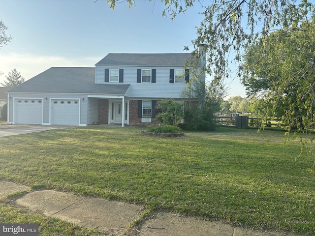 traditional home featuring fence, a garage, a front yard, a chimney, and driveway