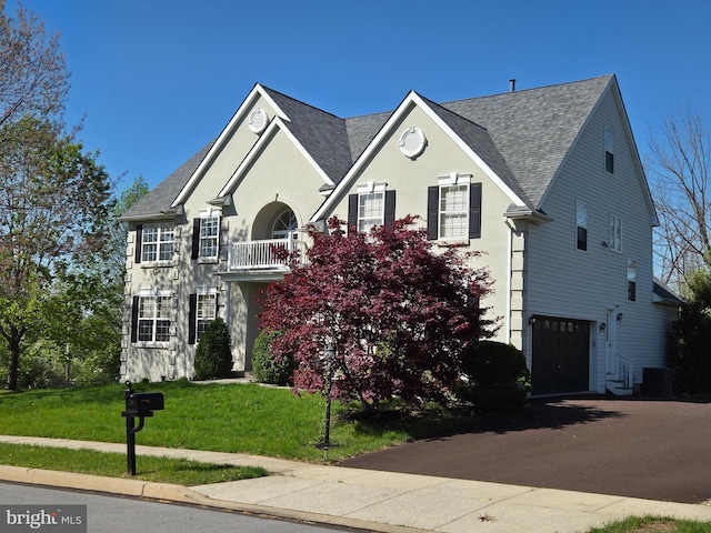 view of front of property with stucco siding, aphalt driveway, a garage, roof with shingles, and a front yard