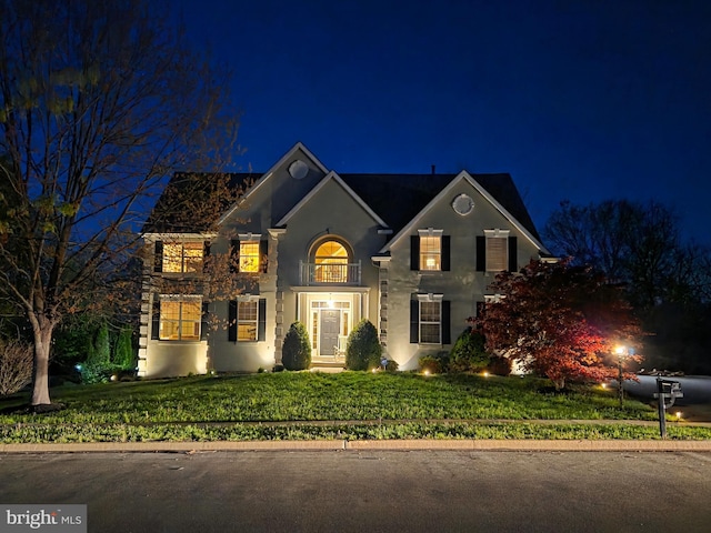 view of front of property featuring a lawn and stucco siding