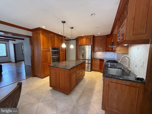 kitchen with tasteful backsplash, dark stone counters, stainless steel appliances, a kitchen island, and a sink