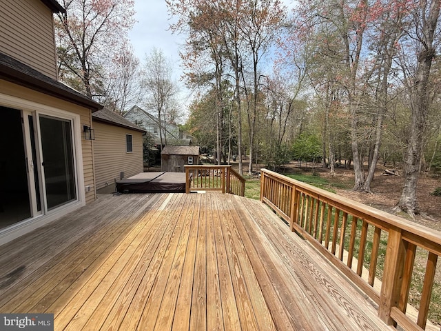 wooden terrace featuring a storage shed and an outbuilding
