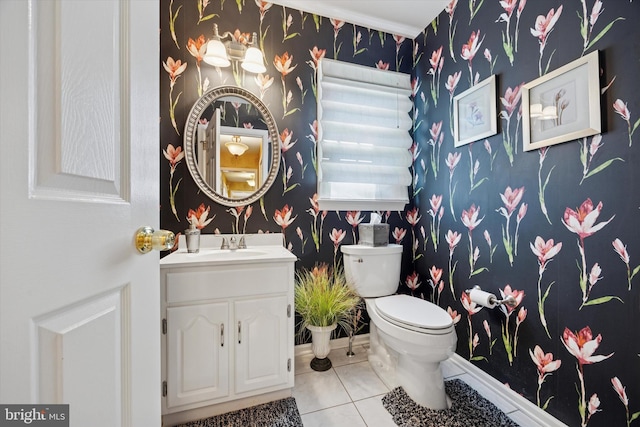 half bath with tile patterned floors, wallpapered walls, toilet, and vanity
